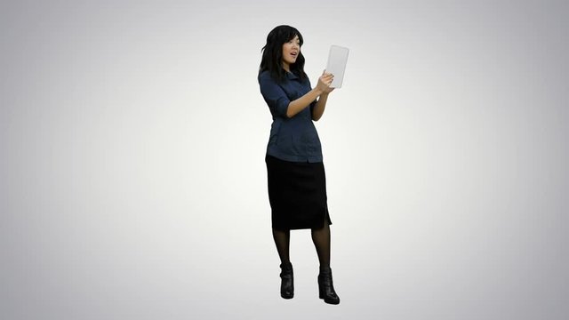 Asian lady having video chat using a tablet on white background