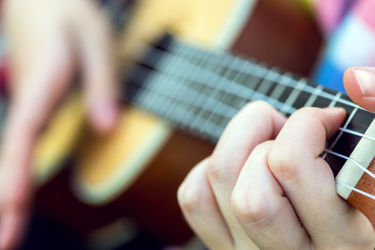 hands playing a guitar close-up