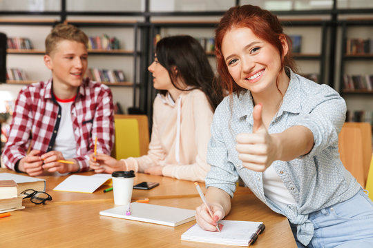 Group of smiling teenagers doing homework