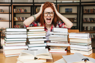 Shocked teenage girl sitting at the library