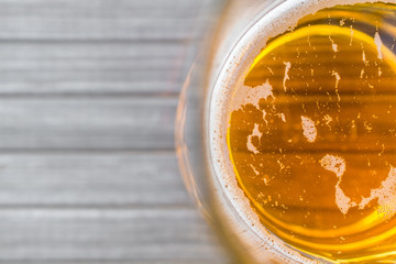 Jug of beer on wooden surface from above with text space
