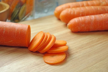 Carrots sliced on wooden chopping board