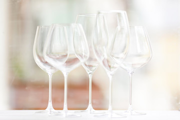 Cristal elegant wine glasses of different shape standing together on a table