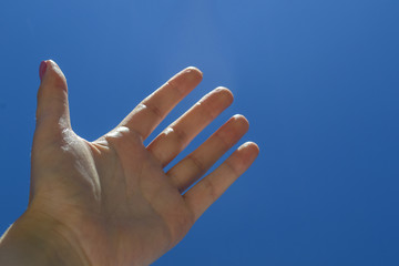 Female arm against a blue sky background.