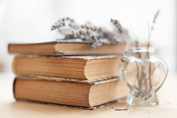 Vintage books with lavender flowers in a glass vase