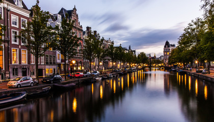 Fototapeta premium Canal in Amsterdam by night with reflections in the water