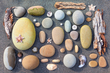 Stone coloured composition with sea stars and shells on a grey sand