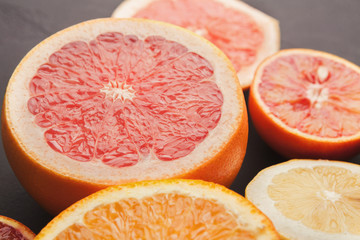 Closeup of juicy citrus fruits on black background