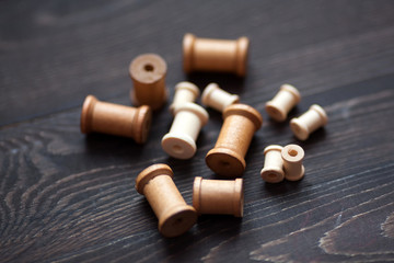 A group of wooden bobbins on a dark background