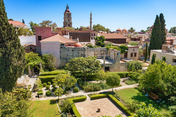 View from city walls into garden with historical buildings in City of Rhodes (Rhodes, Greece)