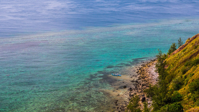 Blue ocean and a shore line with a boat in Mararison island, Philippine