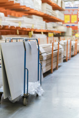 Rows of shelves with boxes and storage carts in modern warehouse