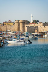 Fototapeta na wymiar Boats in front of entrance gate of medieval city wall in City of Rhodes (Rhodes, Greece)