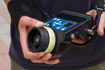 Male hands hold the wireless follow focus system during the filming process.