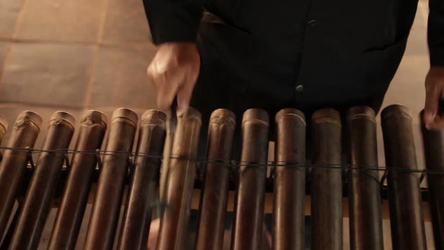 Asian Indonesian Balinese musician gamelan instrument. Closeup hands playing. Not edited, raw file.