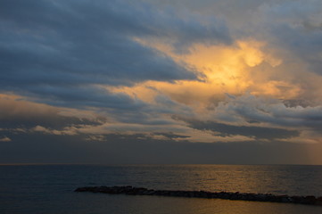 Sunset on the Mediterranean sea from the viewpoint of italy, with cloudy sky