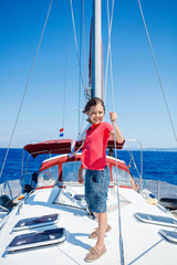 Little boy on board of sailing yacht on summer cruise. Travel adventure, yachting with child on family vacation.