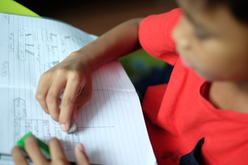 close up a boy doing his homework