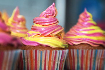 Fresh cupcakes with bright colorful colored cream. Birthday