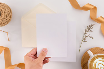 A wedding concept. Wedding Invitation, envelopes, cards Papers on white background with ribbon and decoration. Top view, flat lay, copy space