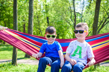 Fototapeta na wymiar Brother and boy relaxing in hammock at vacation