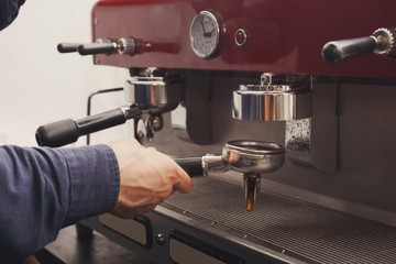 Closeup of barmen hand brewing espresso in cafe