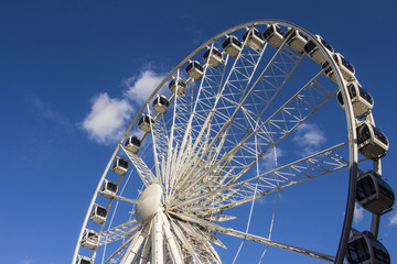 Ferris wheel  on a background of blue sky with clouds