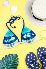 Summer holiday background. Tropical summer concept with fashion accessories, bikini, leaves on bright background.