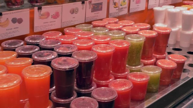 Fresh squeezed fruit juice in plastic cups at La Boqueria market, Barcelona