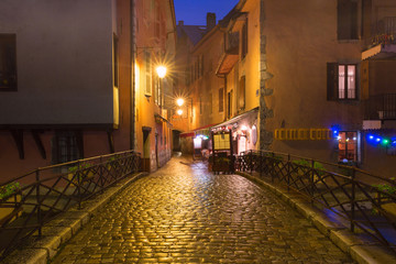 Fototapeta na wymiar Nice street and bridge over Thiou river in Old Town of Annecy at rainy night, France