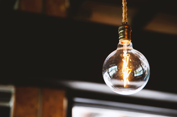 closeup edison lamp with soft-focus and over light in the background