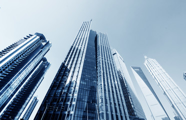 Aerial view of Shanghai's high density central business area. High rise office buildings and skyscrapers with glass surface. Urban roads with multiple lanes and green city park. Shanghai, China