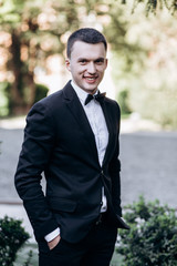 The handsome groom stands and waits for his bride