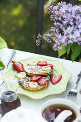 Pancakes with fresh strawberries and banana.