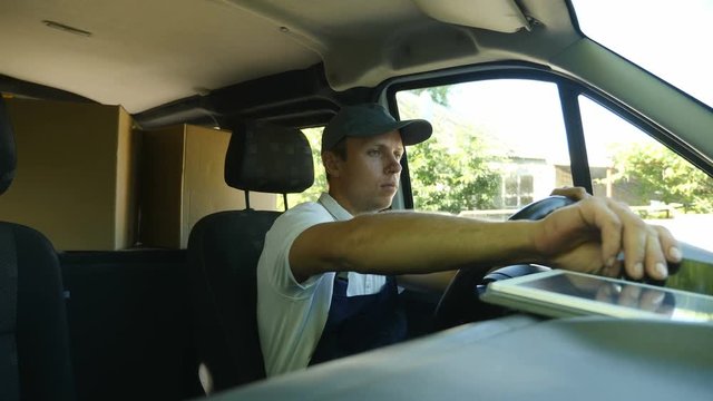Delivery service. The courier drives the car. The courier drove up to the house of the recipient, the man is calling by phone