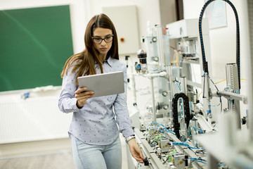 Young female student of robotics stands in a lab © BGStock72