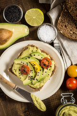 Avocado Spread Guacamole and Slices with Fresh Cherry Tomato and Black Sesame. Healthy Breakfast Concept.