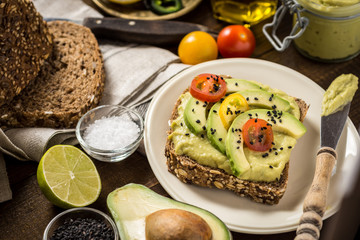 Avocado Spread Guacamole and Slices with Fresh Cherry Tomato and Black Sesame. Healthy Breakfast Concept.