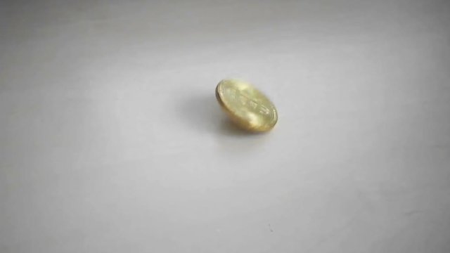 Gold coin bitcoin spinning on the table