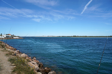 This is river fishing with long fishing rods and baits due to bright sunshine
