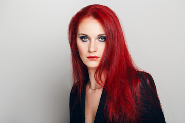 Fototapeta premium Closeup portrait headshot of beautiful sexy young redhead Caucasian woman with green eyes. Middle age female with long ginger hair. Studio beauty shot.