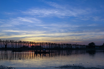 Obraz premium Sunset at the U Bein Bridge at the Taungthaman Lake near Amarapura, Myanmar. The bridge, built around 1850, 1.2 km long, is the longest teakwood bridge in the world.