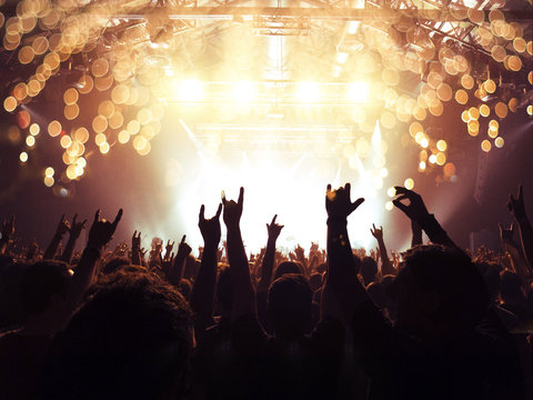 Concert Spectators In Front Of A Bright Stage With Live Music, Fireworks Are Visible.