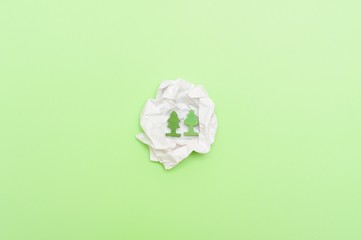 Small Green plants in crumpled wite paper. On green background. World environment day reforesting...