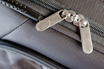 two macro slider zippers fastened on gray suitcase