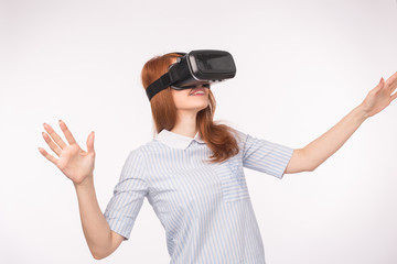 Happy young red-haired woman using a virtual reality headset