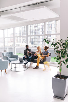 three adults having buisness meeting in big office