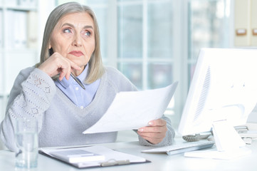 senior woman working at table with computer 