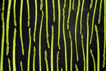Fresh green asparagus pattern, top view. Isolated over black. Food background asparagus flat lay pattern