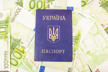 Ukrainian passport against the background of Euro-accounts with a face value of 100